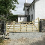 Rustic wooden farm gate with sturdy construction, installed at the entrance of a rural property. Crafted from durable timber, perfect for countryside estate or home driveway access.