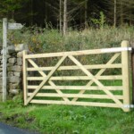 Wooden driveway gate installed between stone pillars, part of Richard Hope Wooden Gates collection, showcasing durable and handcrafted timber fencing solutions for privacy and curb appeal.