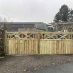 Handcrafted wooden driveway gates with decorative cross-batten design, weatherproof finish, and sturdy posts, providing privacy and enhancing property curb appeal. Custom wooden gates by Richard Hope Wooden Gates.